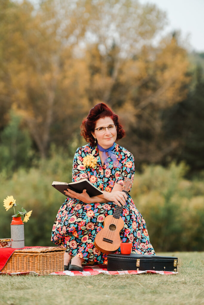An Edmonton musician holds a book and reading while holding her ukelele