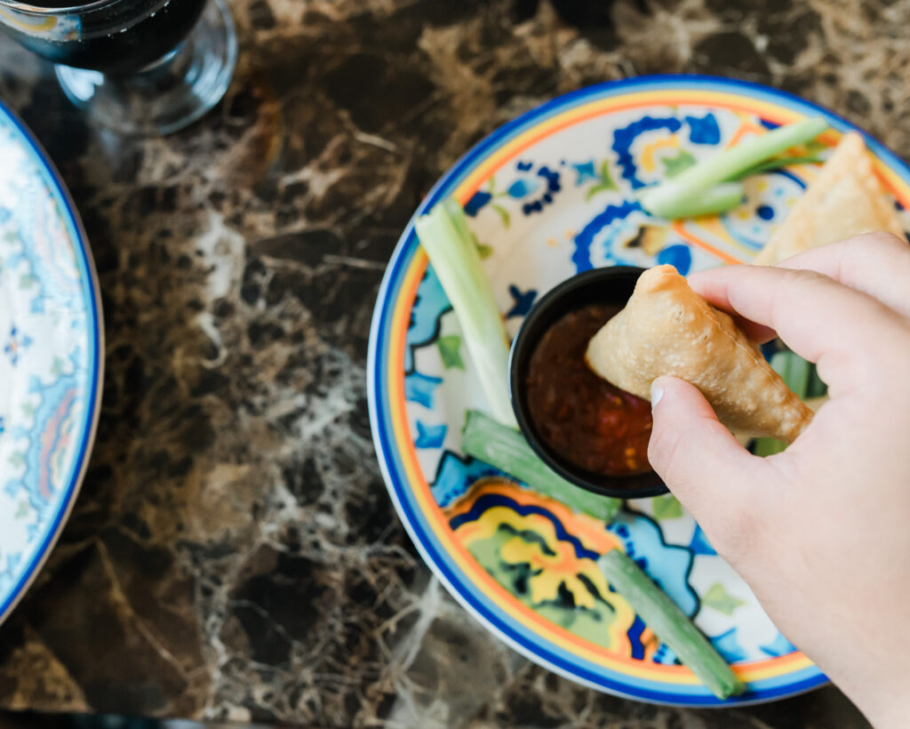 Close up of samosa being dipped at an Afghani Edmonton restaurant