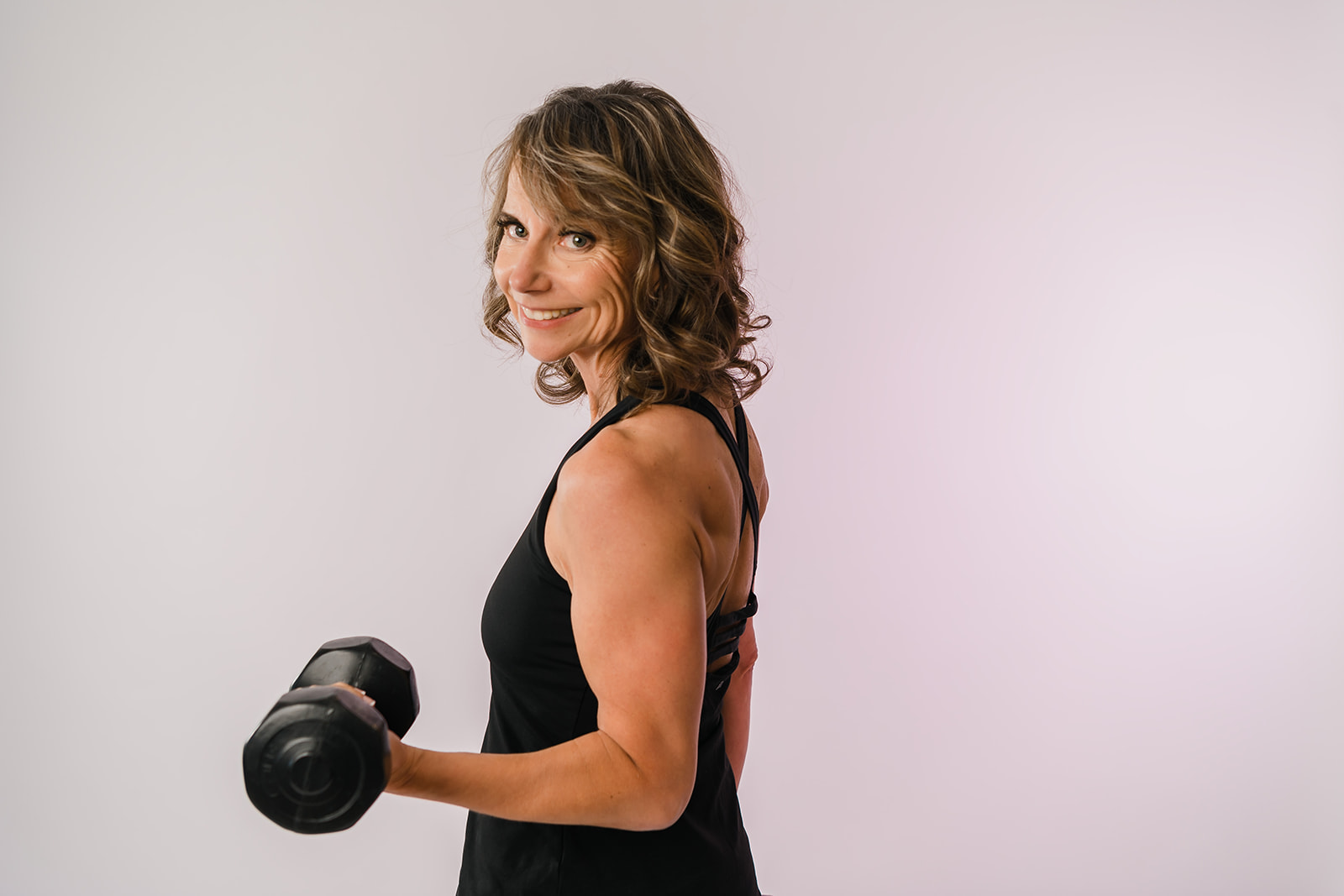 A clean studio branding portrait of a woman over 40 years of age showcasing strength and confidence for her personal branding photography session in Edmonton with Cynthia Priest Photography