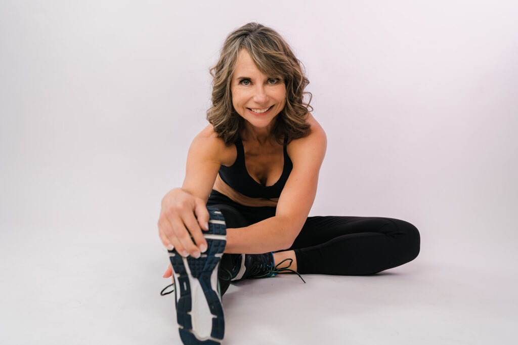 A female nutritionist Sue Lemoine stretching during her personal branding photography with Cynthia Priest